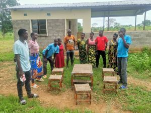 Jugendlich aus dem Youth Empowerment Programm begutachten ihre selbst hergestellten Möbel.